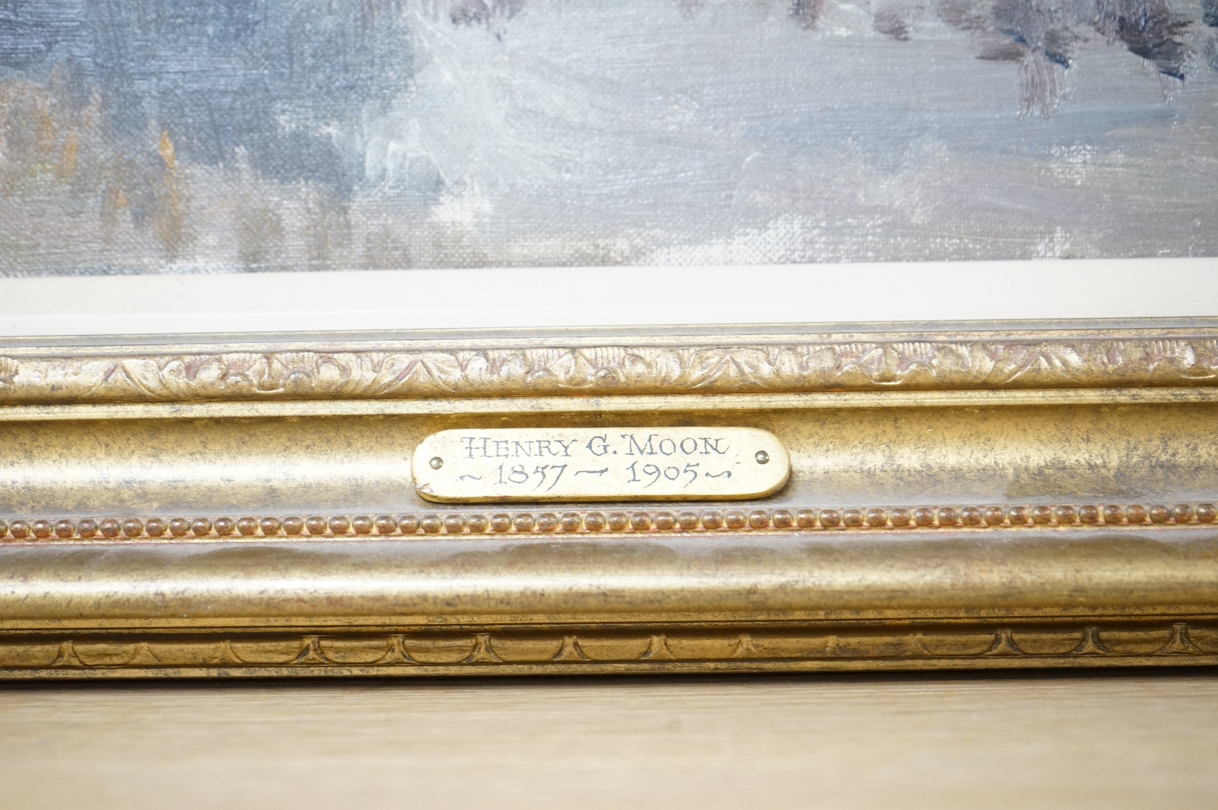 Henry G. Moon (1857-1905), oil on canvas, Riverscape, signed in ink verso, 24 x 44cm, applied plaque to the gilt frame. Condition - good